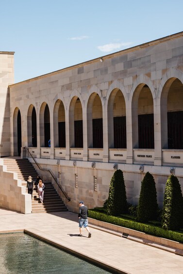 A building with arched windows and a staircase leading to a pool area. 3