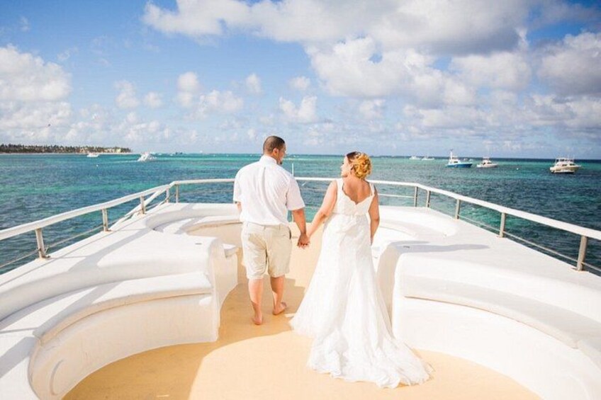 A couple on a boat with a clear view of the ocean and distant boats. 5