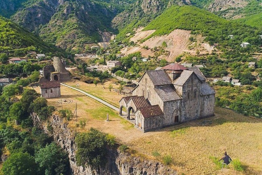 A mountainous landscape with a church, a small tower, and a path. 1
