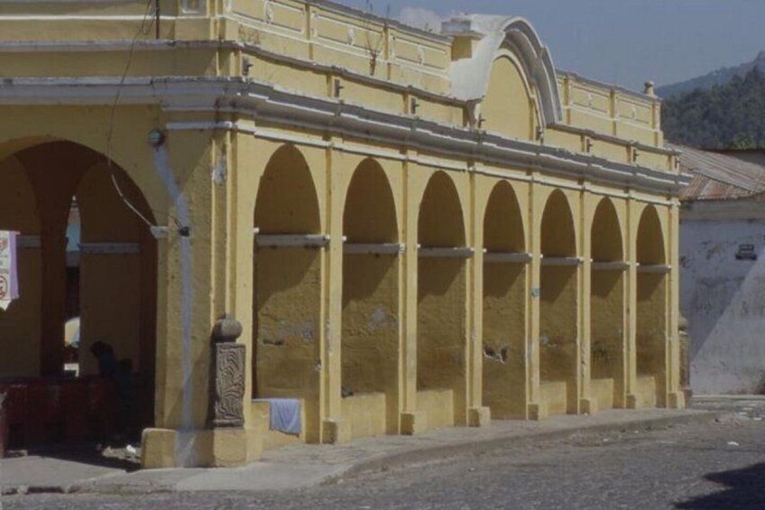 A yellow building with arched windows and a balcony. 4