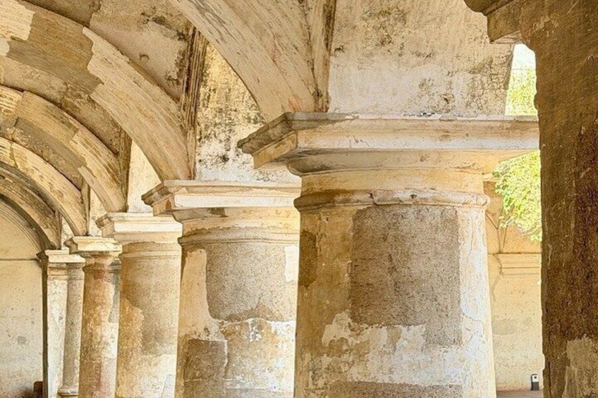 An ancient stone structure with columns and arches. 5