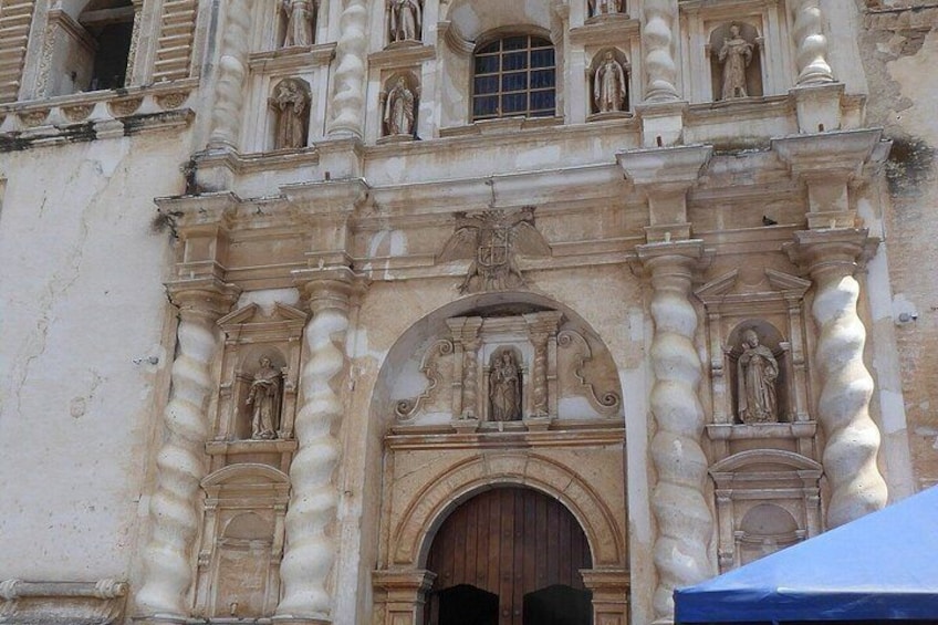 A historic building facade with ornate columns, statues, and a central arched doorway. 2