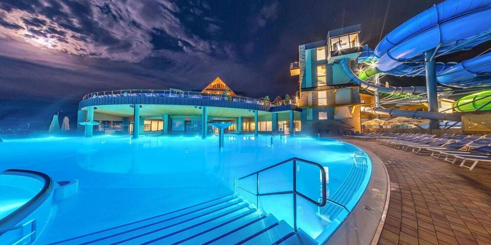 A swimming pool with a water slide and lounge chairs. 3