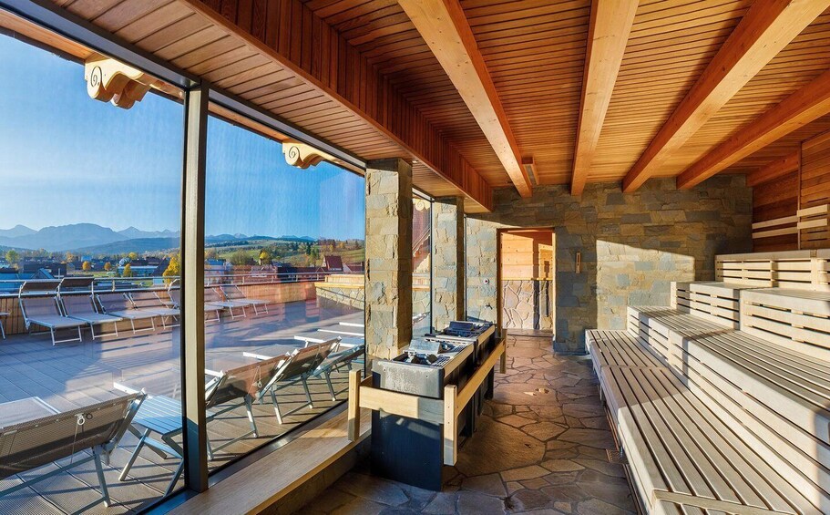 A wooden ceiling, stone walls, and a view of mountains. 5