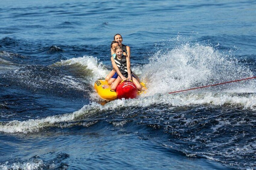 A person wakeboarding on a yellow board with a red life jacket, being pulled by a rope. 2