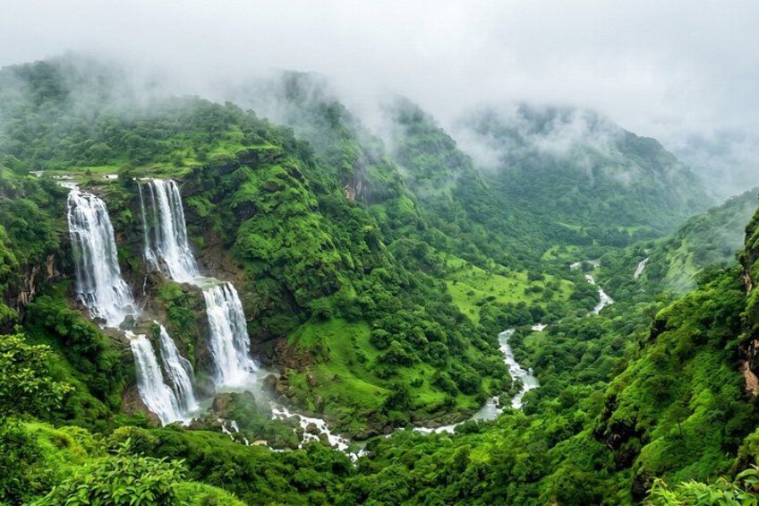 A lush green valley with multiple waterfalls cascading down the hills. 1
