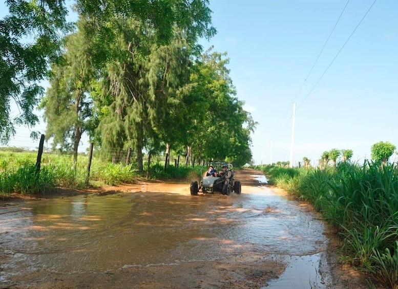 A muddy road with a vehicle and two people. 2