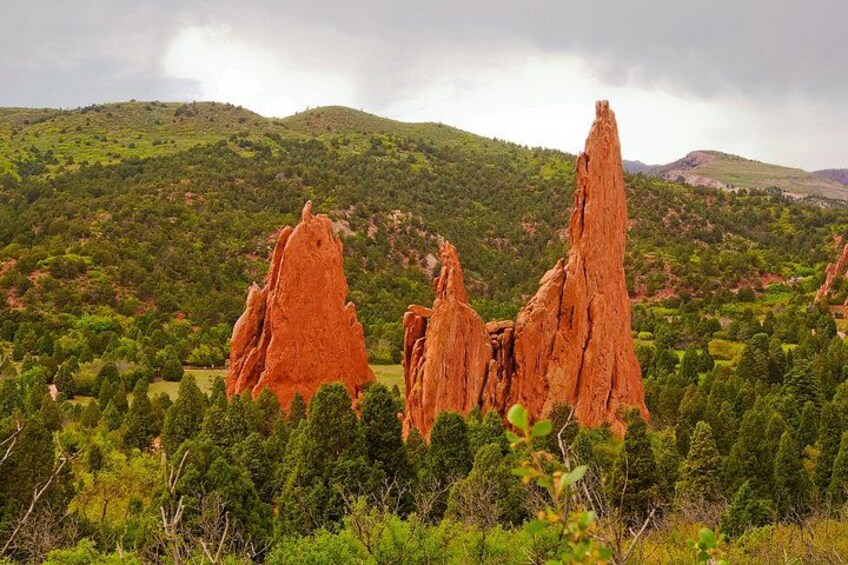 A landscape with red rock formations and green hills. 2