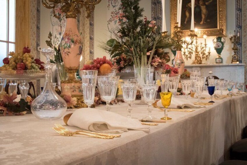 A formal dining table with glassware, cutlery, and floral arrangements. 5