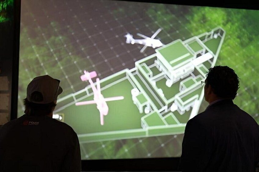 Two people observing a projected architectural model. 4