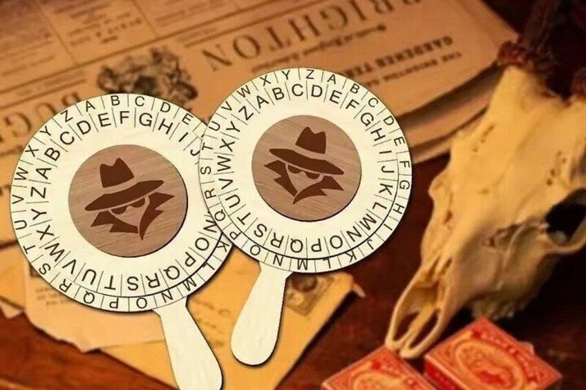 Two circular wooden objects with symbols and letters, placed on a surface with a newspaper and a white cloth. 3