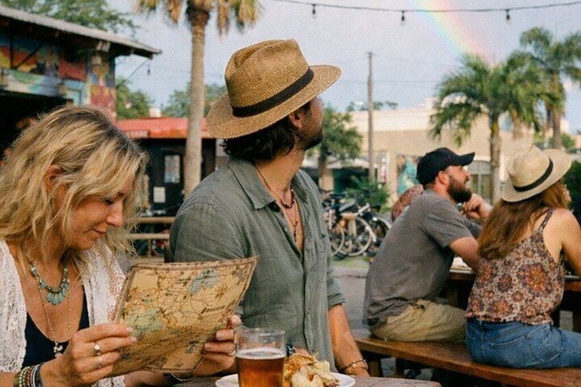 People sitting at a table with a map and a drink. 5