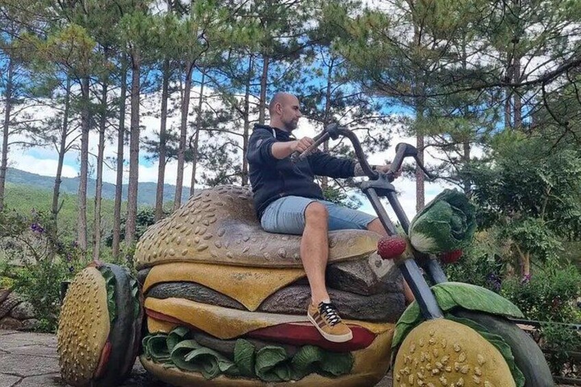 A person riding a vehicle shaped like a giant hamburger. 2