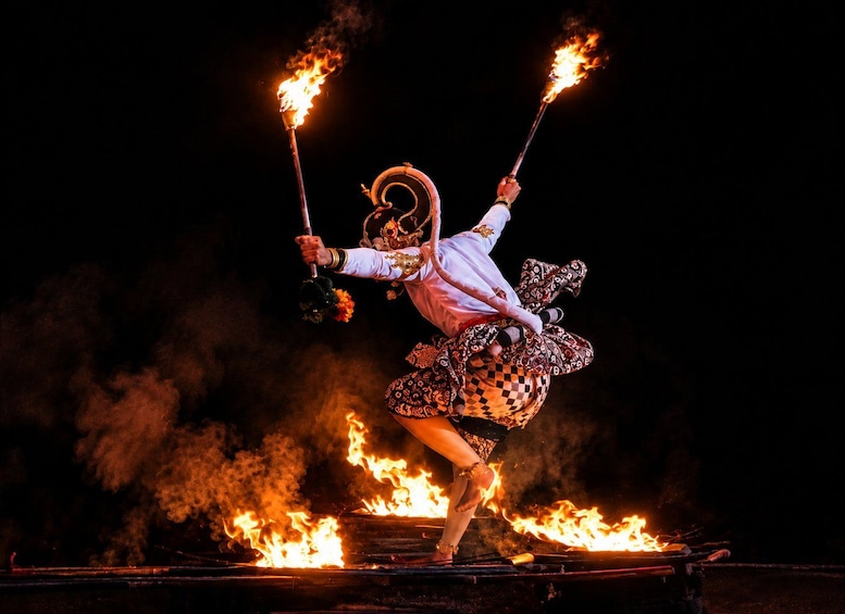A performer juggling flaming torches and balancing on a flaming platform. 1
