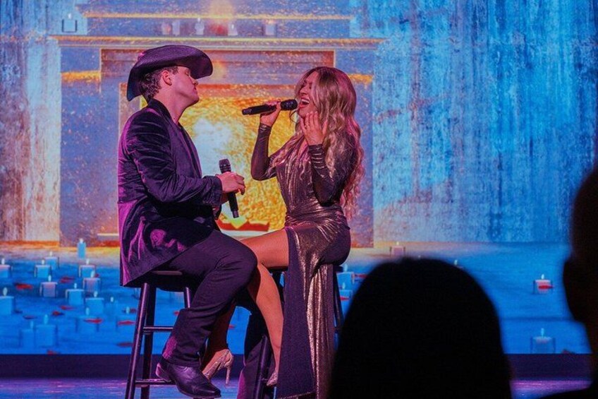 Two people on stage, one holding a microphone. 5