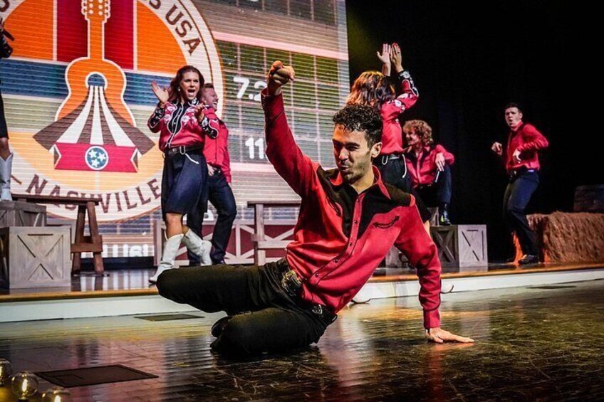 A person performing a dance on a stage with a large guitar-shaped backdrop and the text 'NASHVILLE USA'. 3