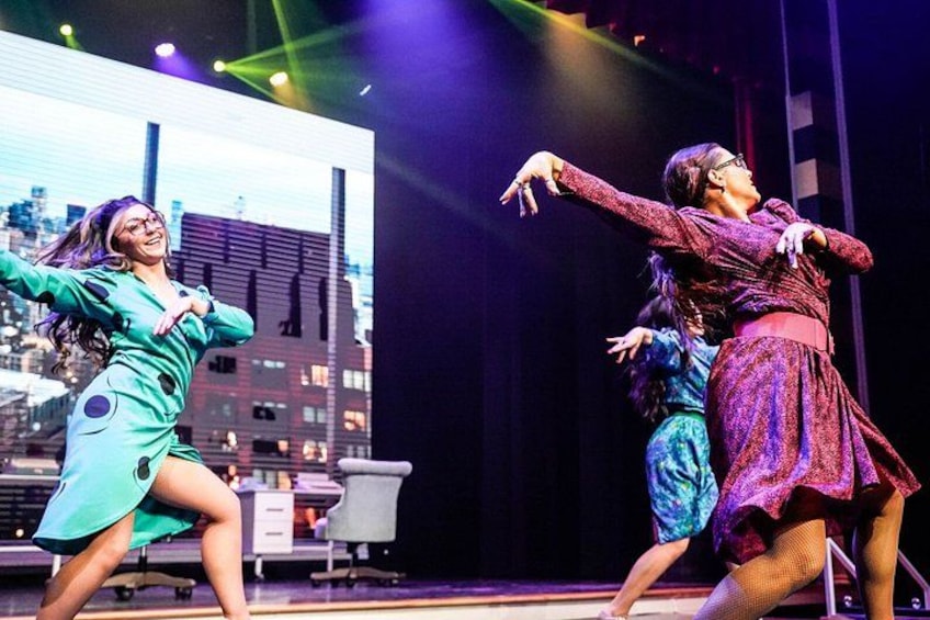 A stage with dancers in colorful costumes performing a dance. 3