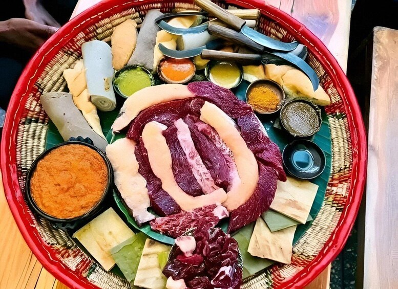 A traditional Japanese meal with various meats, tofu, and condiments on a woven tray. 4