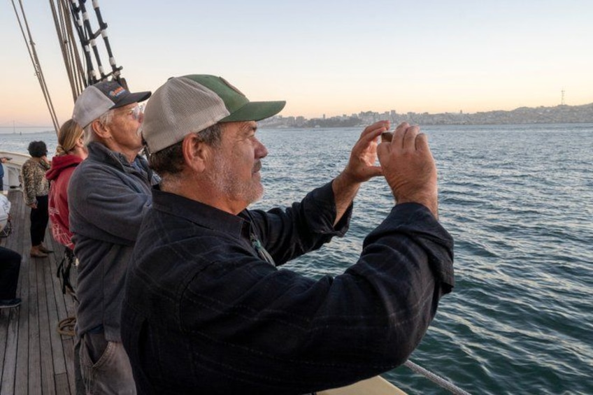 A person taking a photo with a camera on a boat. 2