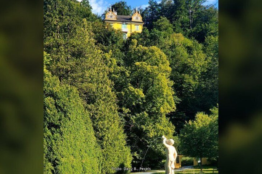 A statue in a park with a building in the background. 2