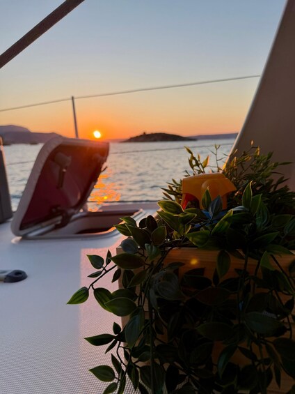 A sunset over water with a laptop and a plant on a boat. 4