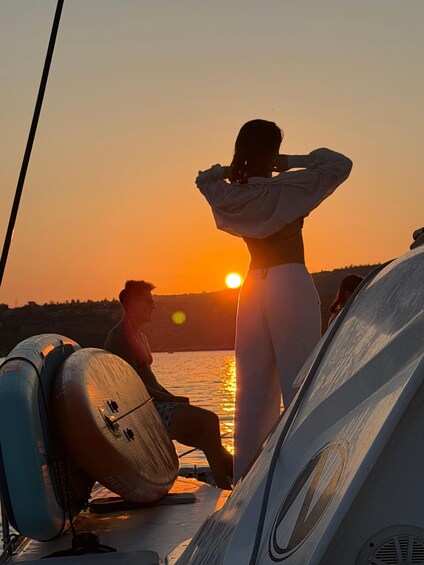 A sunset over a body of water with people on a boat. 2