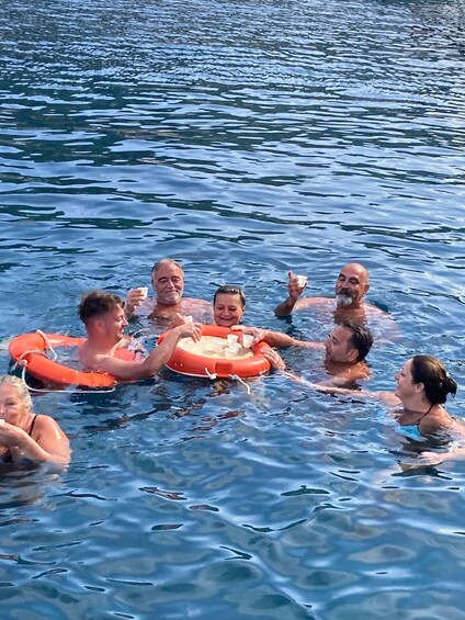 A group of people floating on water with inflatable rings. 5