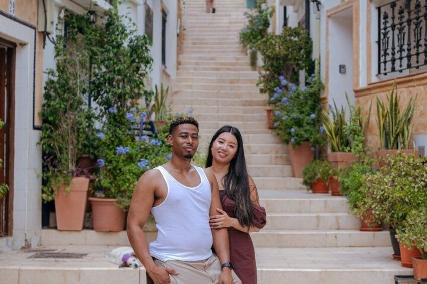 A man and a woman standing on a staircase with potted plants. 4