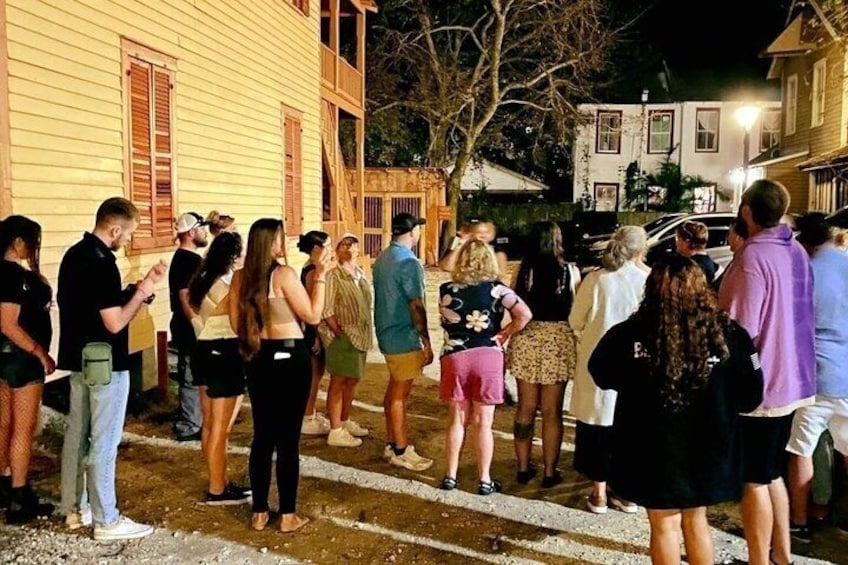 A group of people standing on a street at night. 4