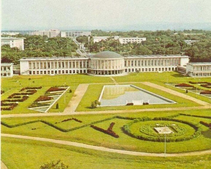 A large building with a circular courtyard and rectangular garden beds. 1