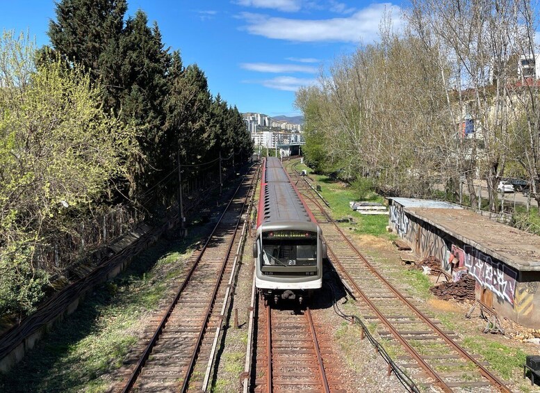 Un treno sui binari, con una stazione sullo sfondo. 3