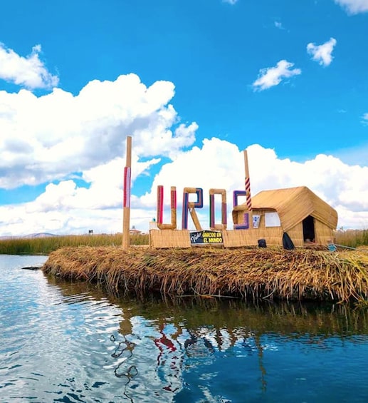 A thatched-roof structure with 'URUGUAY' spelled out in colorful letters, a flag, and a sign reading 'UNICOS EN EL MUNDO' on a floating platform in a body of water. 5