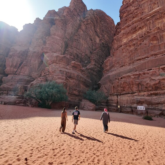 A desert landscape with red rock formations and a sandy path. 3