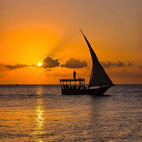 A boat with a person standing on the deck during sunset. 3