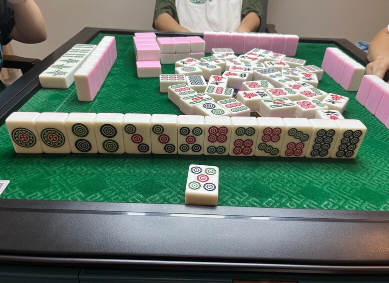 A mahjong table with tiles and a single tile in the foreground. 3