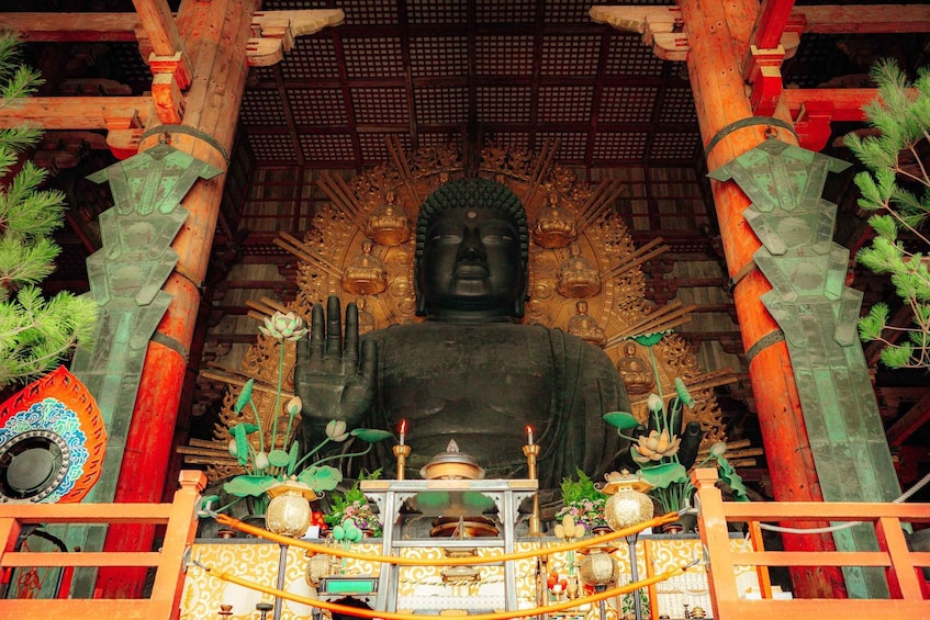 A large Buddha statue surrounded by ornate decorations and offerings. 2