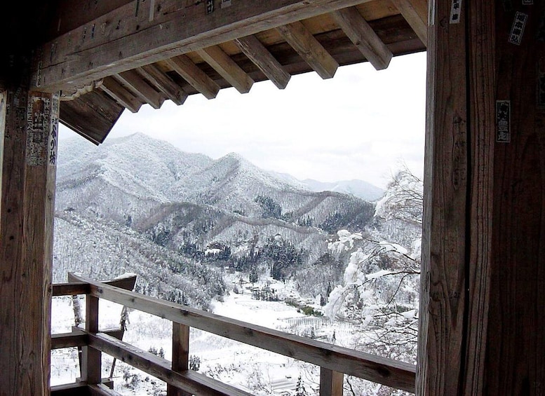 A wooden cabin with a view of snow-covered mountains. 5
