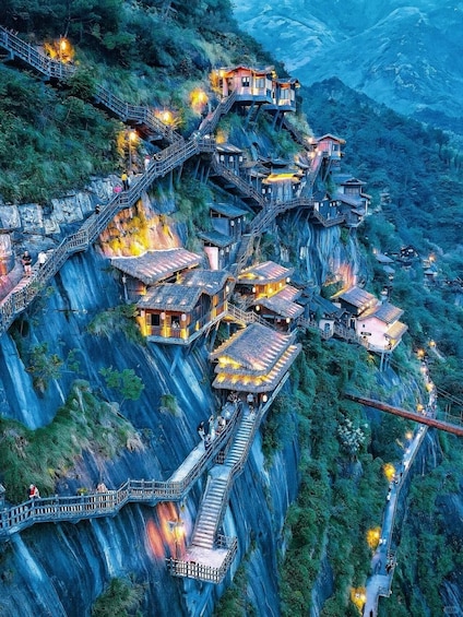 A series of traditional wooden houses built on steep mountain cliffs, connected by winding staircases and walkways. 1