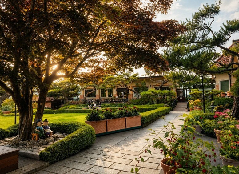 A landscaped garden with a pathway, benches, and a building in the background. 4