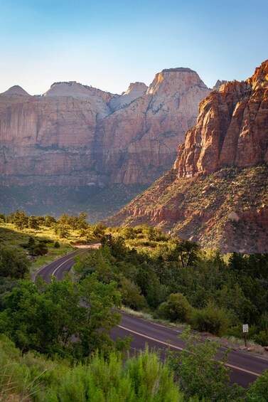A winding road through a canyon with rocky cliffs and sparse vegetation. 5
