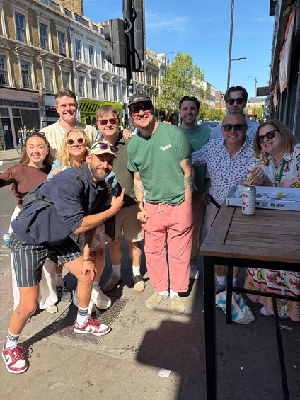 A group of people posing for a photo on a city street with buildings and a traffic light in the background. 5
