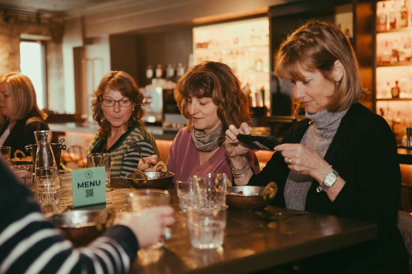 A group of people dining at a restaurant with a menu stand visible. 4