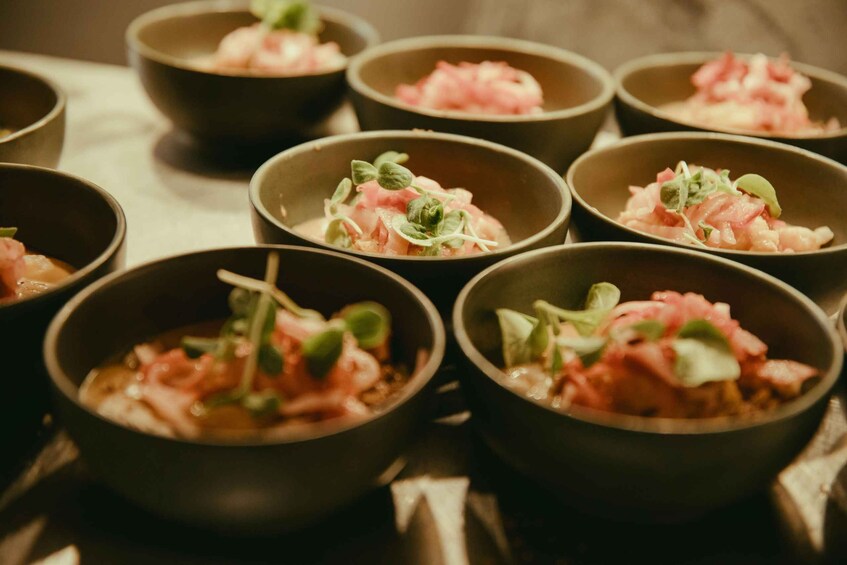 Bowls of food with pink toppings and green leaves. 2