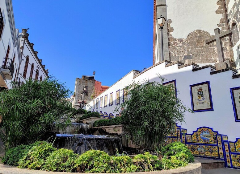 A historic building with a fountain and lush greenery in front. 2