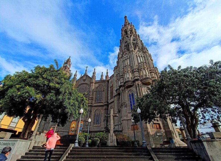 A Gothic-style cathedral with intricate architecture, a large rose window, and a statue of a saint at the entrance. 5