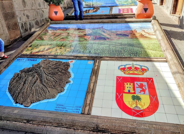 A tiled map of Gran Canaria with a coat of arms and a mountain range. 4