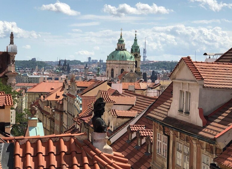 A cityscape with a prominent green-roofed church and a tall tower in the background. 4
