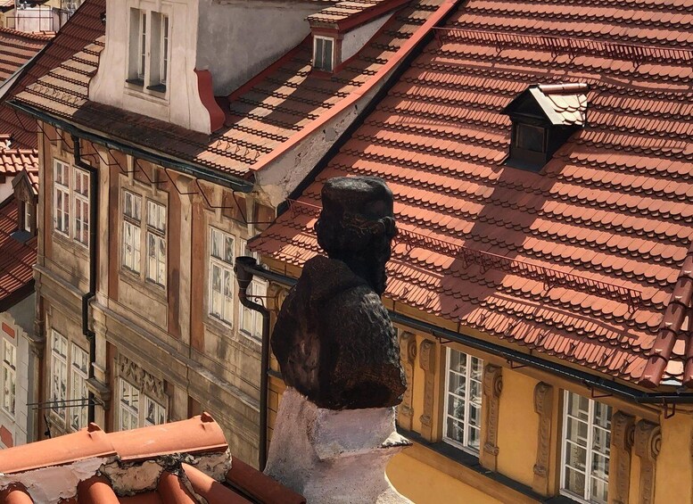 A statue on a building with red-tiled roofs and ornate windows. 2