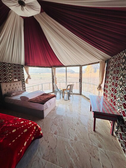 A bedroom with a bed, a bench, and a view of the desert landscape. 1