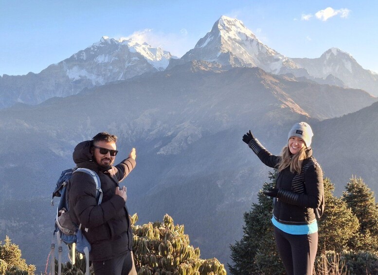 Two people hiking with a mountain range in the background. 4